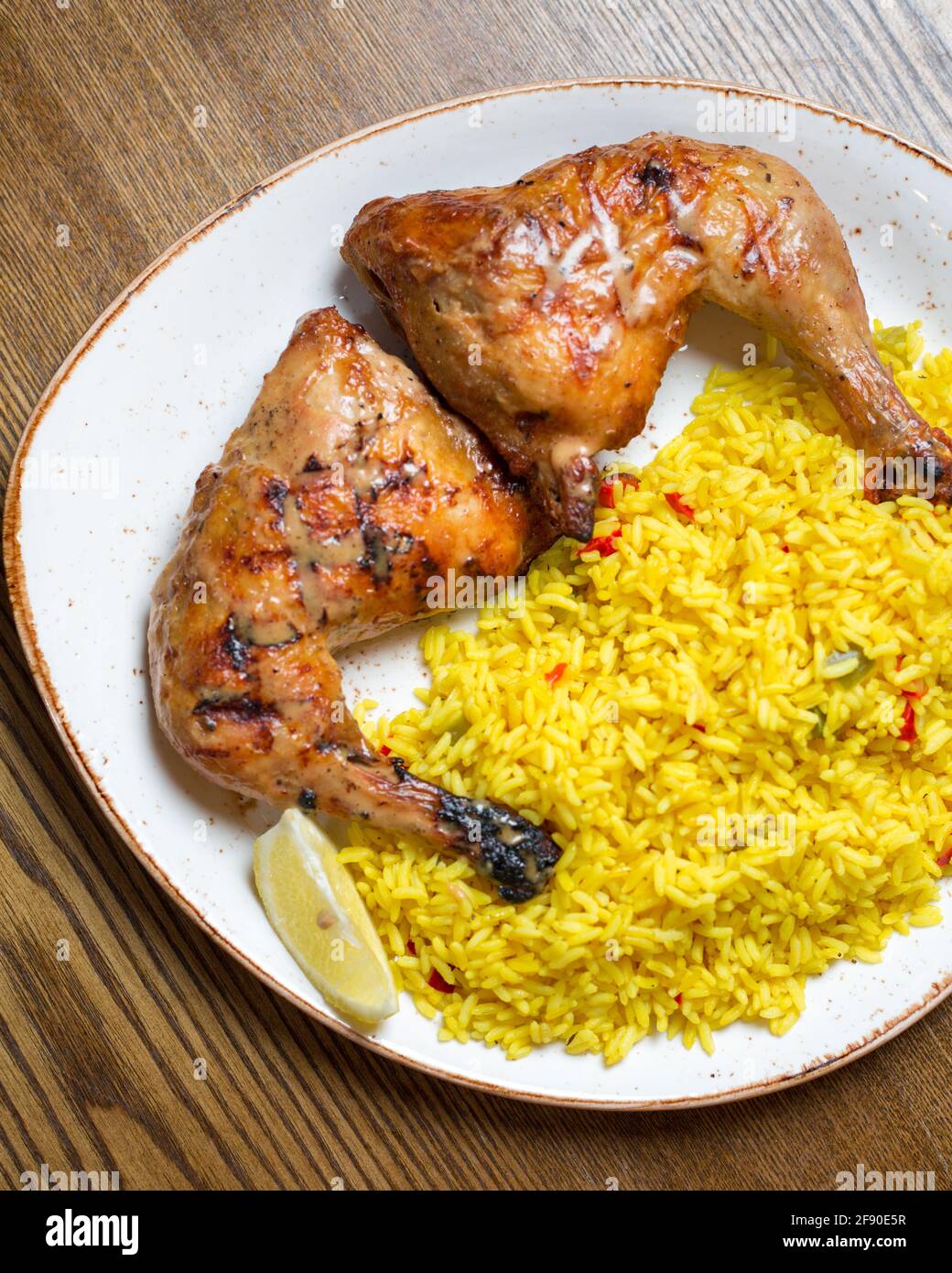 Vertical top view of roasted chicken legs and yellow rice Stock Photo ...