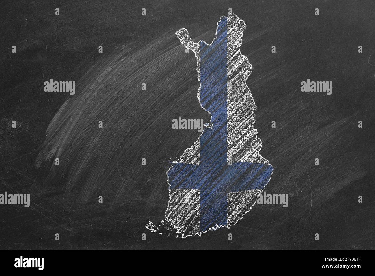 Country map and flag of Finland drawing with chalk on a blackboard. One of a large series of maps and flags of different countries. Education, travel, Stock Photo