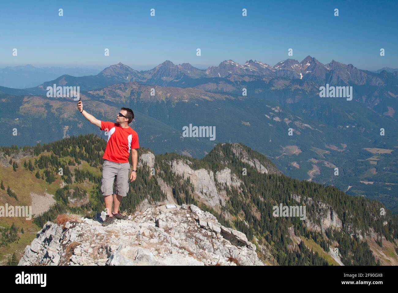 Man looks for phone connection while hiking in the mountains. Stock Photo