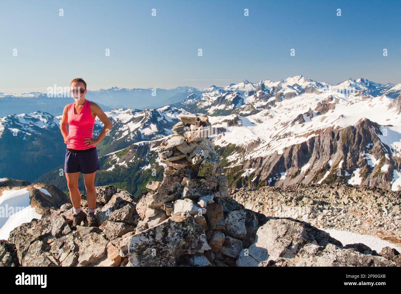 Portrait of attractive female trail runner on mountain summit, Canada Stock Photo