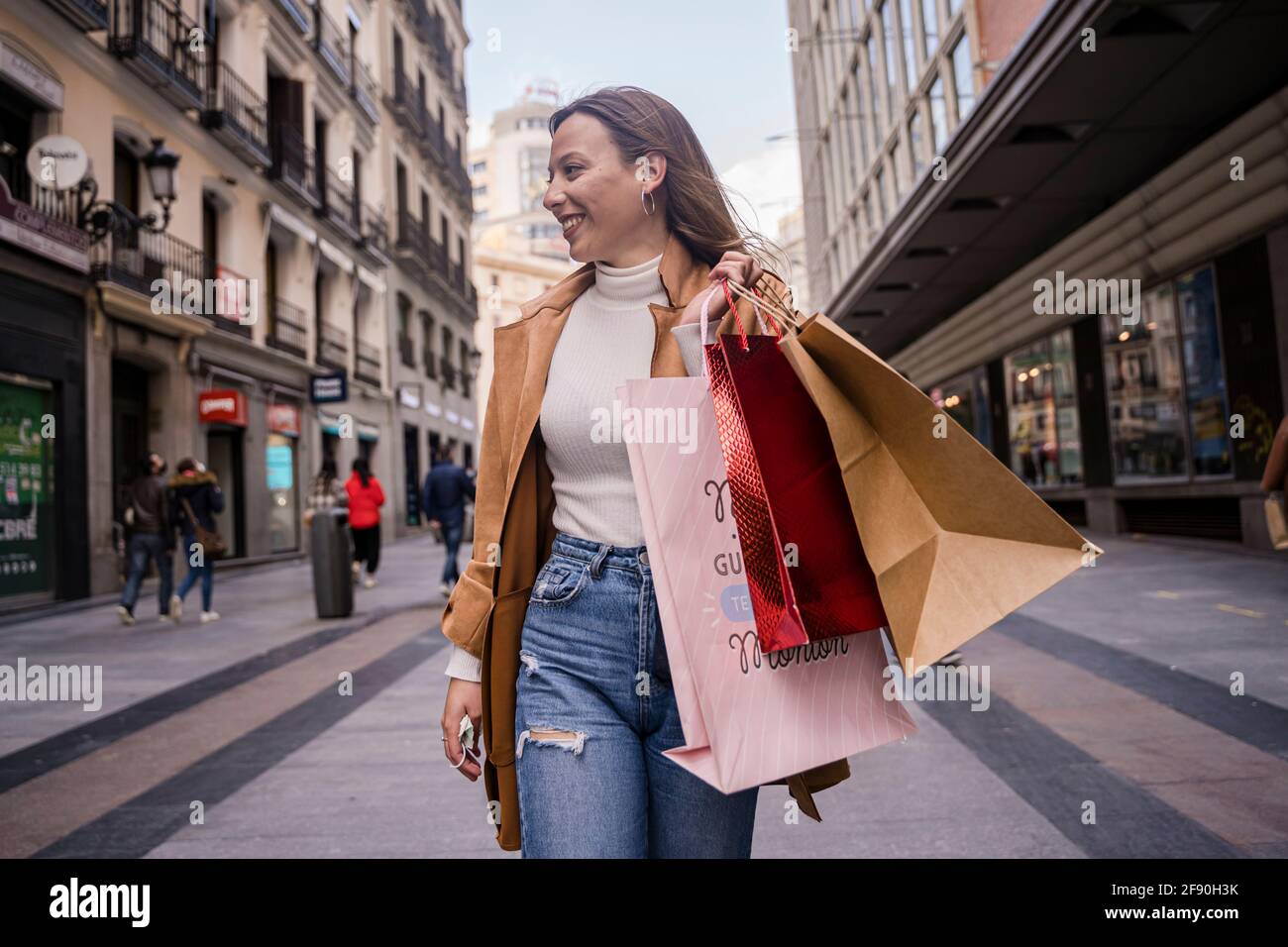 Beautiful woman holding shopping bags and smiling Stock Photo - Alamy