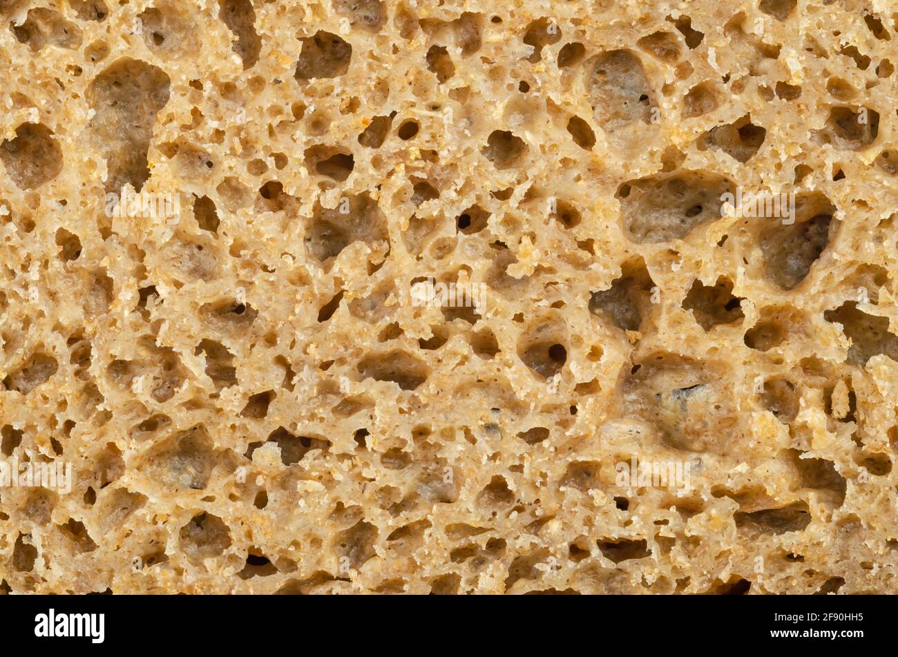 Surface of a fresh cut rye bread, close-up from above. Brown colored sourdough bread, a mix of rye grain flour, leaven and spices, baked in an oven. Stock Photo