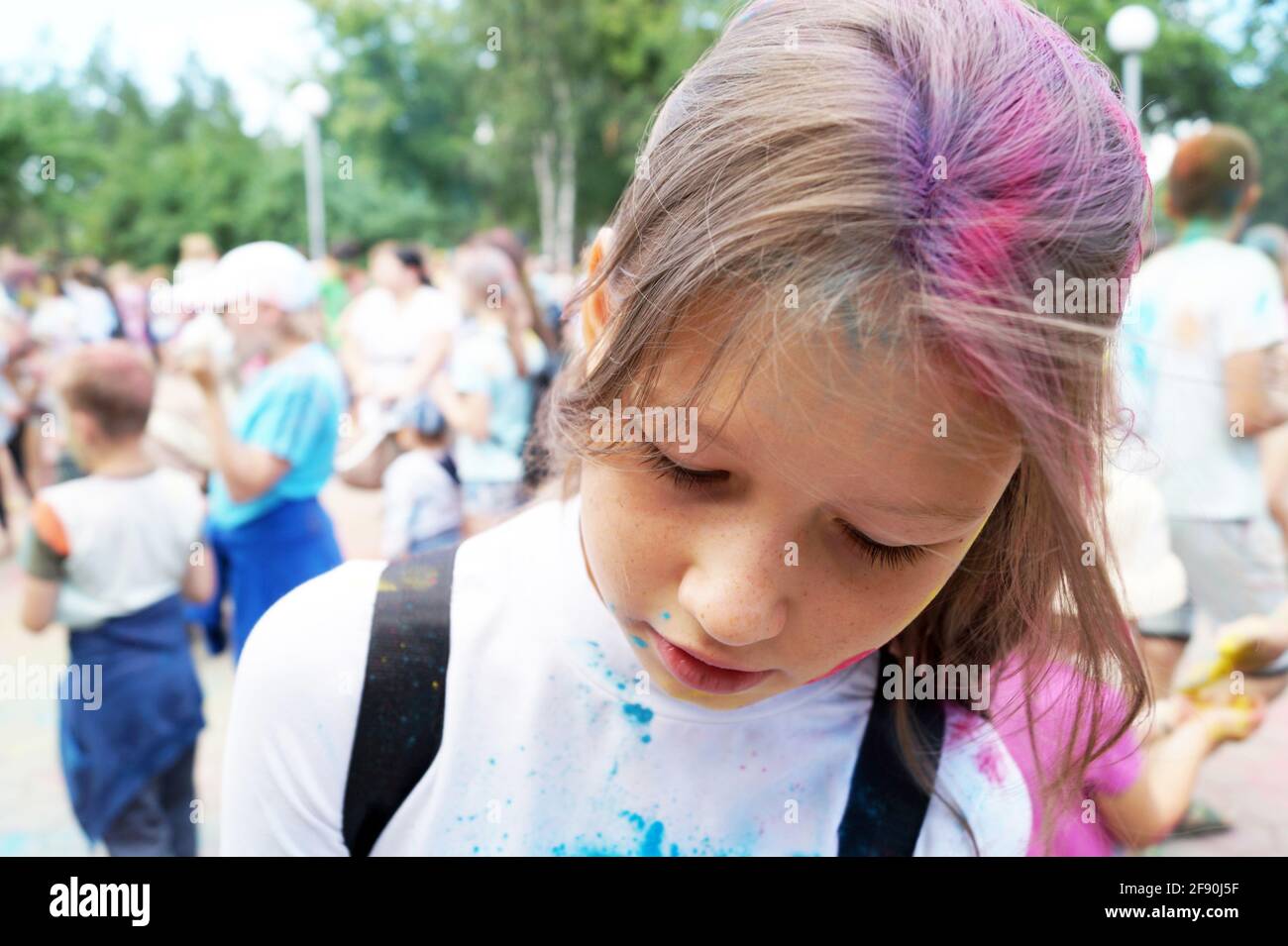 A girl 10-15 years old stained with paint lowered her head down Stock Photo