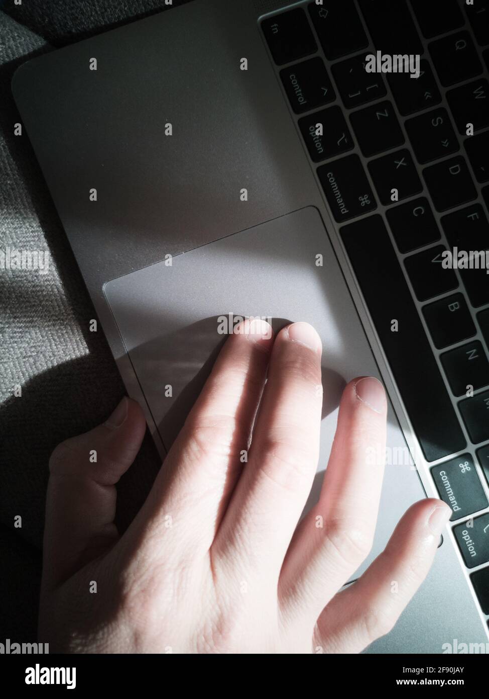 Man's hand on the laptop keyboard touchpad. Top view. Stock Photo
