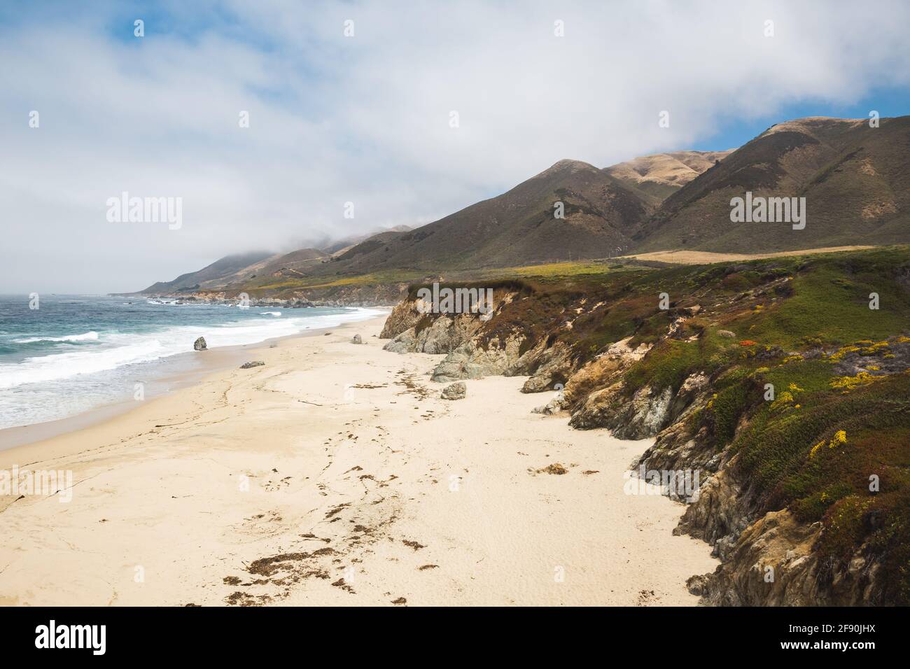 Rugged coastline of Big Sur with sandy beach and cloudy sky Stock Photo ...