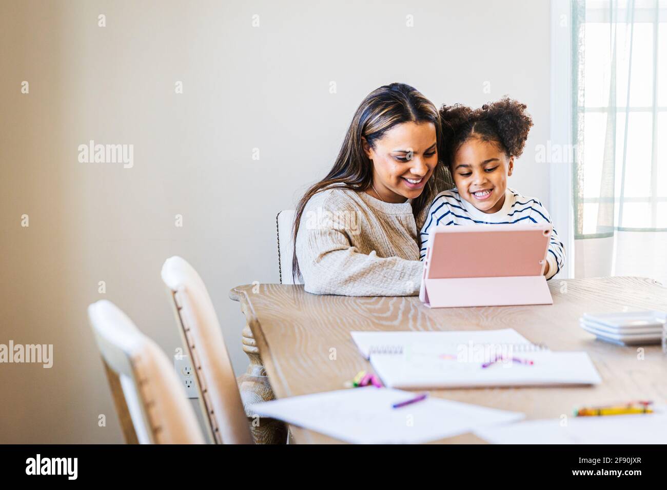 Happy woman and daughter using digital tablet at home Stock Photo