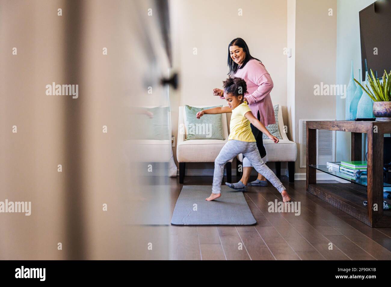 Girl practicing dance with smiling grandmother at home Stock Photo