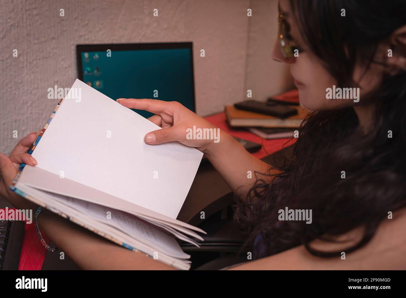 pretty middle aged latin woman reading in her work area Stock Photo