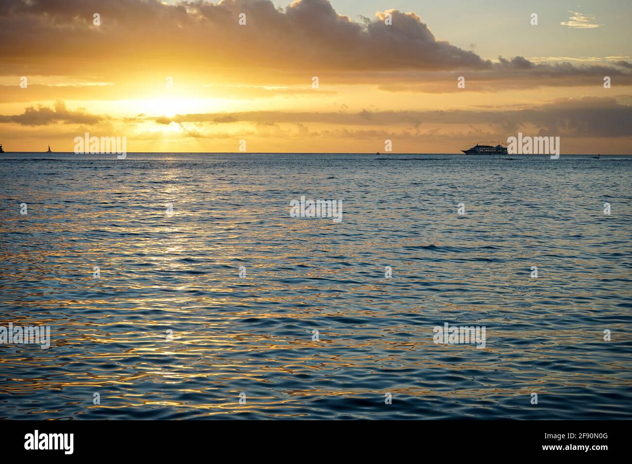 Cruise ship sailing in front of sunset at Waikiki Beach, Honolulu, Oahu