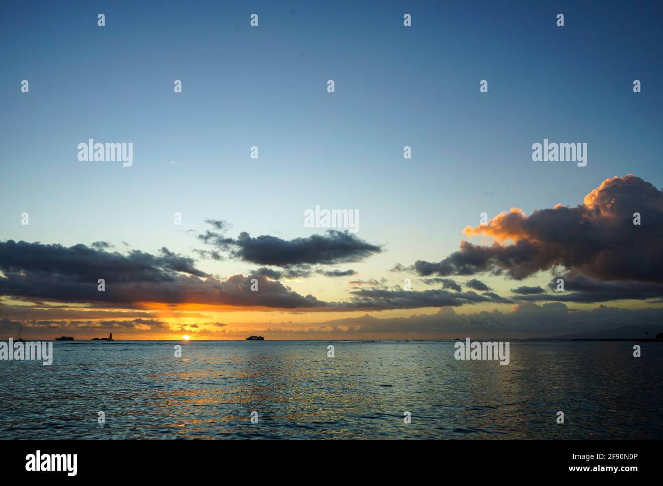 Cruise ship sailing in front of sunset at Waikiki Beach, Honolulu, Oahu