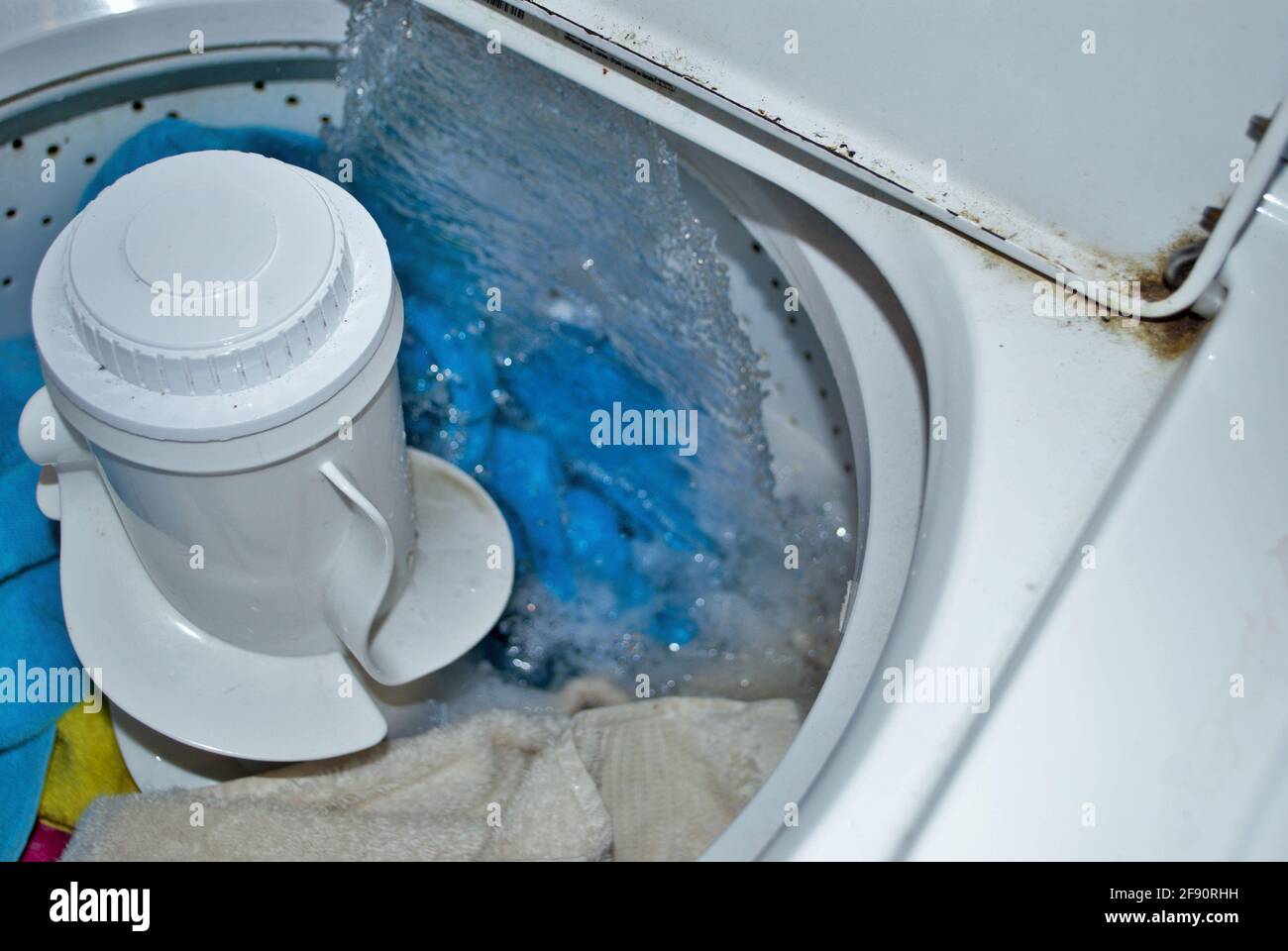 load of dirty towels in a washing machine filling with water Stock