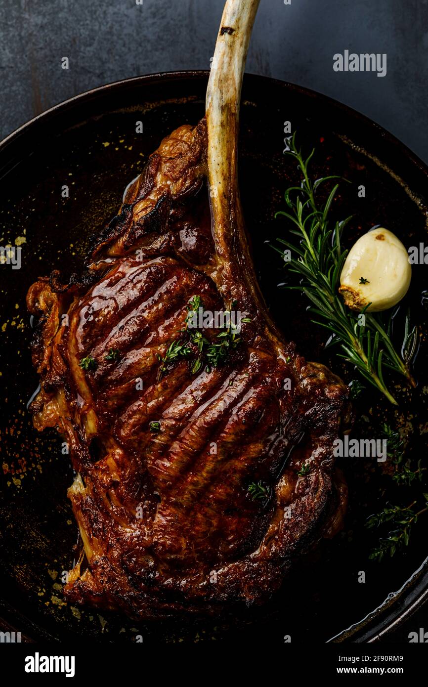 Barbecue grilled Tomahawk Steak dark background close-up Stock Photo