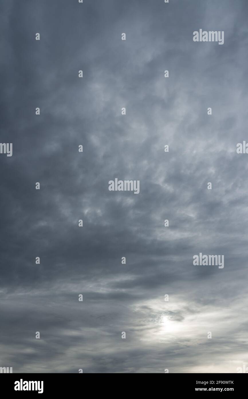 Vertical photo of a majestic gray sky with sun over horizon. No birds, no noise. Sun through stormy clouds. Stock Photo