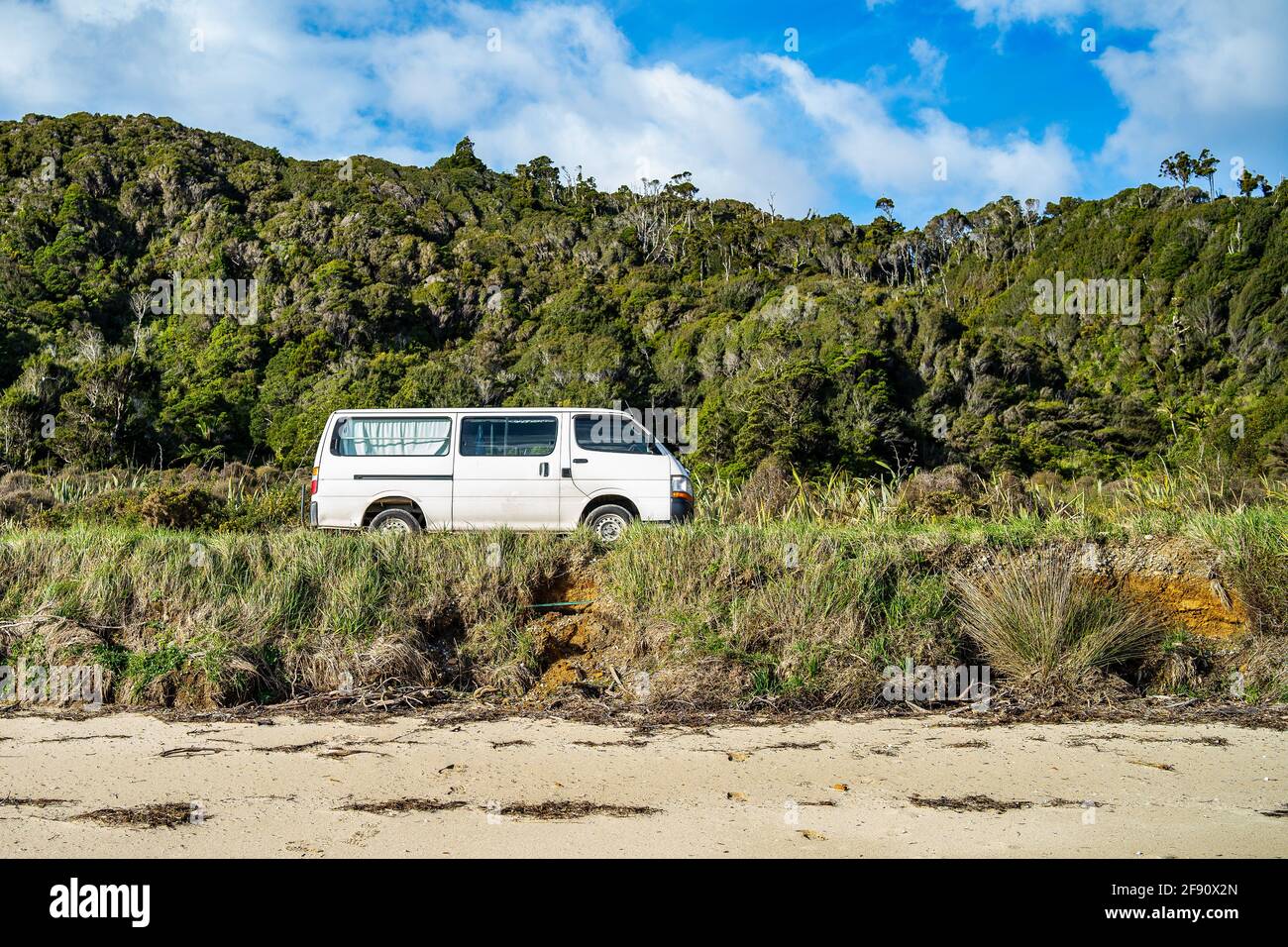 White van passing through the plain with trees and greenery background Stock Photo