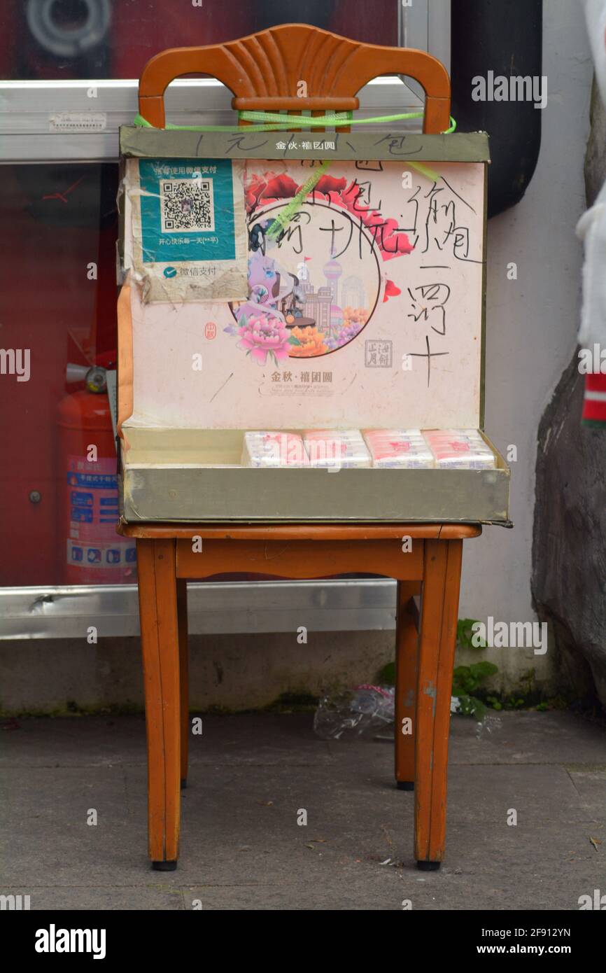 Tissue for sale outside of a Chinese toilet, people can take a pack and pay using wechat or weixin. Very few toilets in China supply paper. Stock Photo