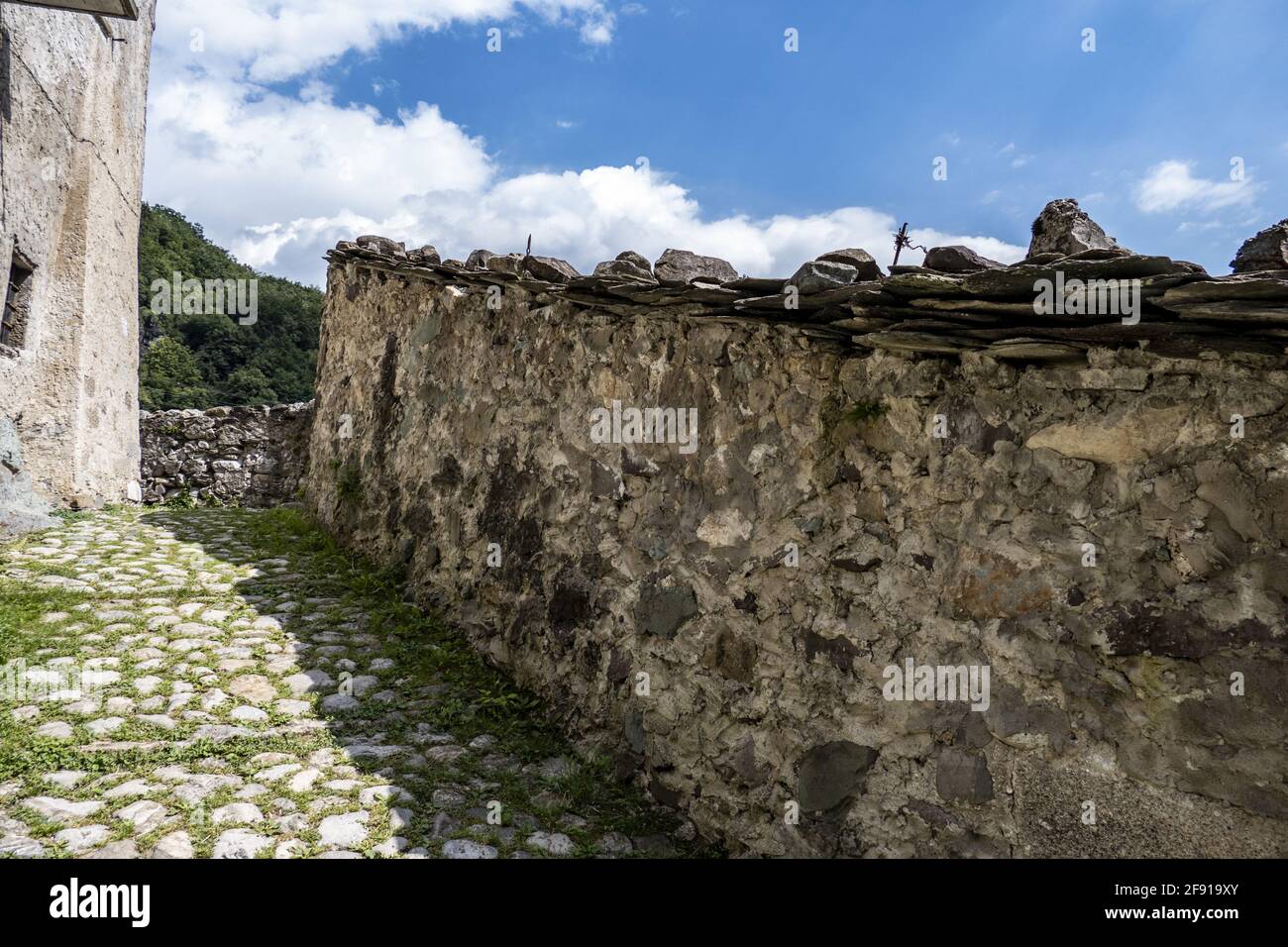 Rocky wall surrounding an old house in Cornello dei Tasso, ancient medieval village, Italy Stock Photo