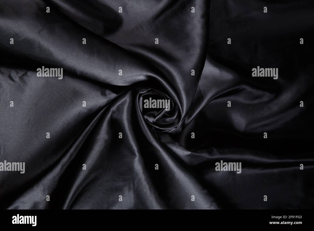 https://c8.alamy.com/comp/2F91FG3/colored-black-textile-satin-fabric-folded-in-folds-and-waves-with-highlights-and-texture-shimmers-in-the-light-2F91FG3.jpg