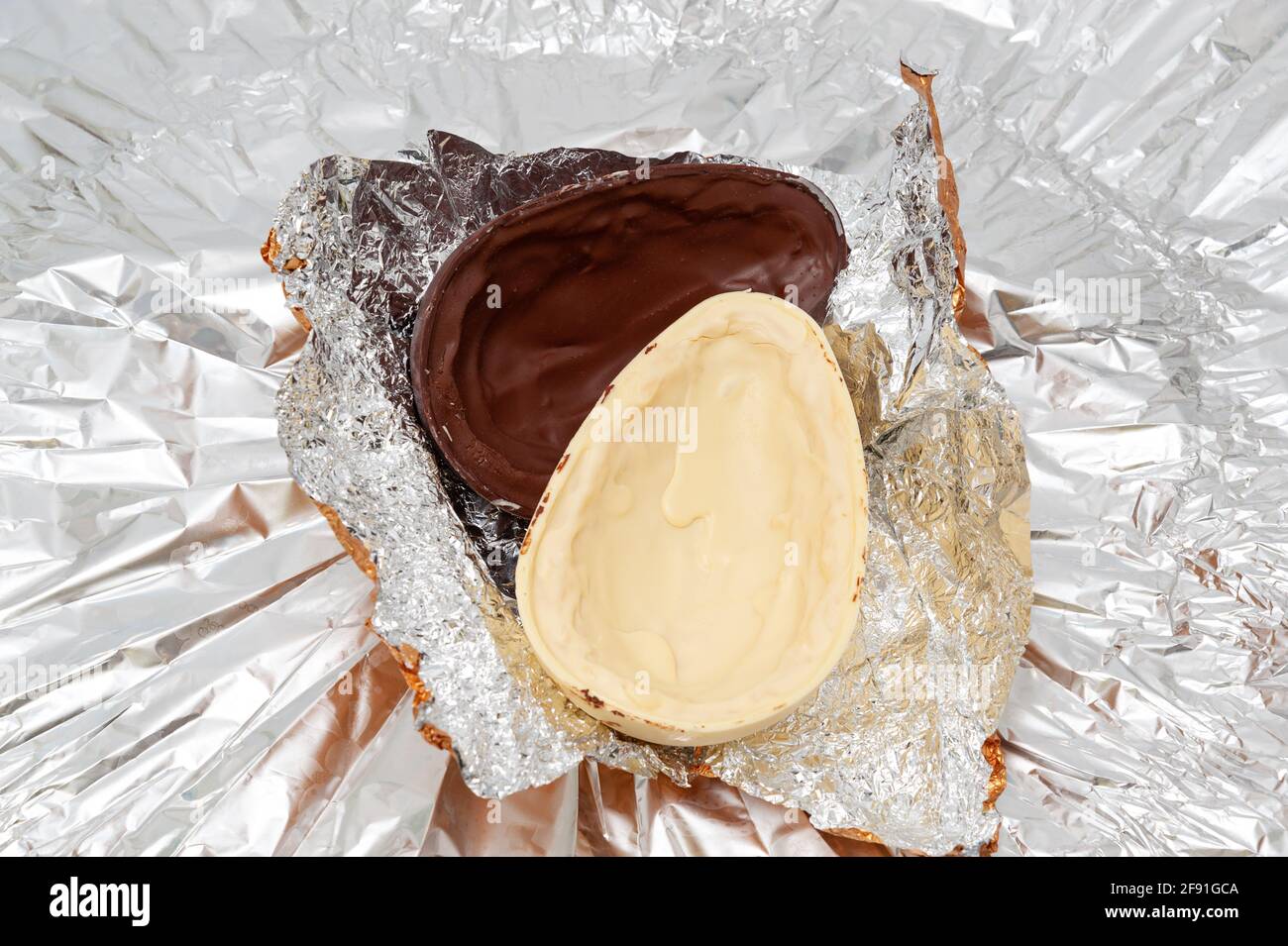 Easter Egg Unpacking chocolate egg in aluminum foil. Top view Stock