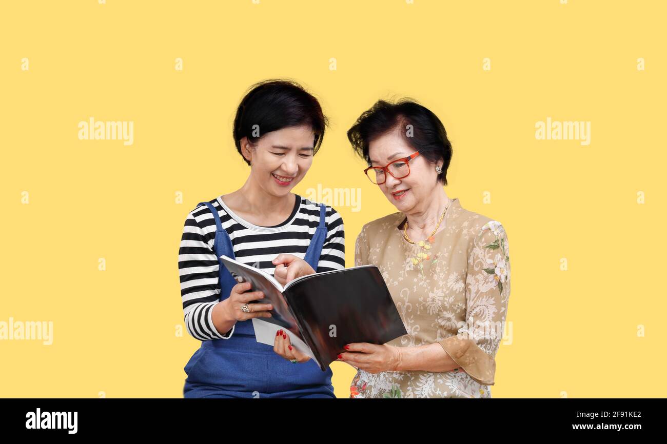 Senior woman reading a magazine with her daughter Stock Photo