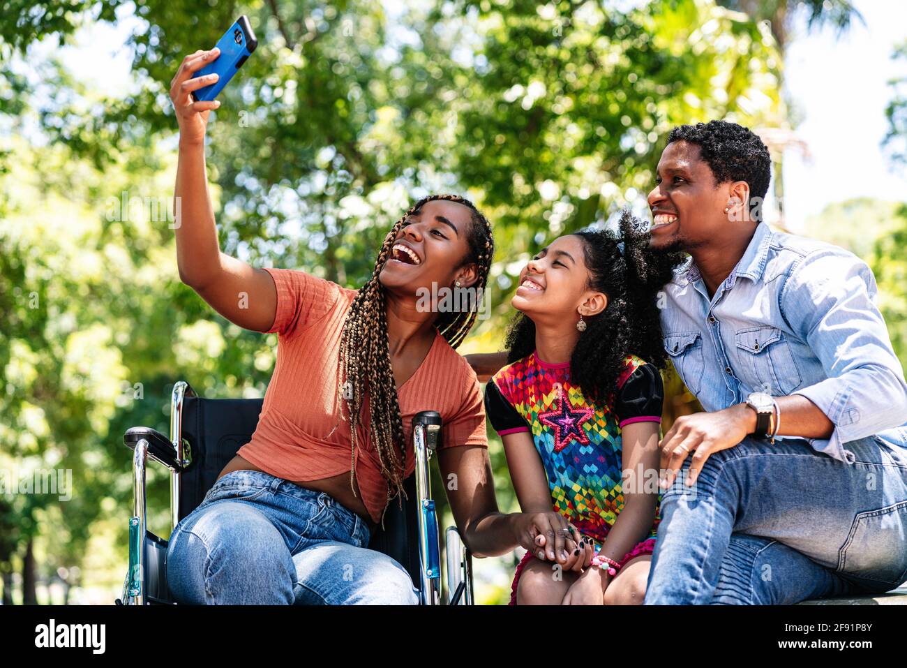 Woman in a wheelchair taking a selfie with her family Stock Photo - Alamy