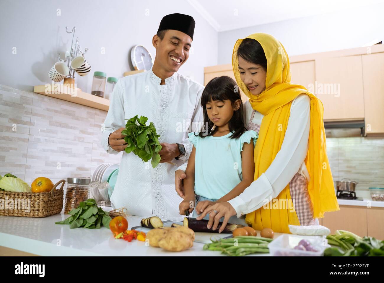 muslim parent and kid cooking and preparing for iftar dinner on ramadan Stock Photo