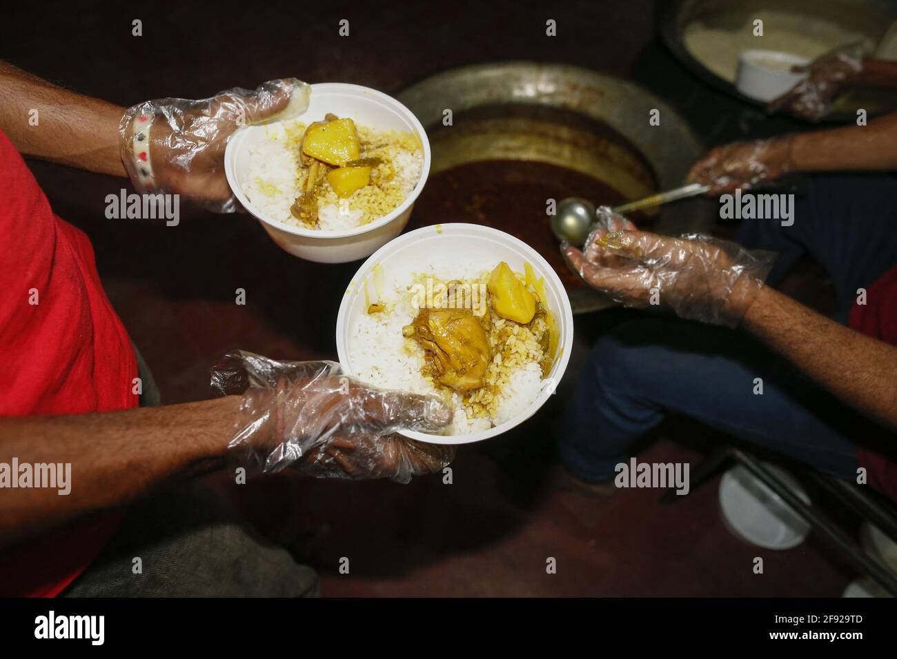 During night volunteers prepare meals for homeless people, struggling ...