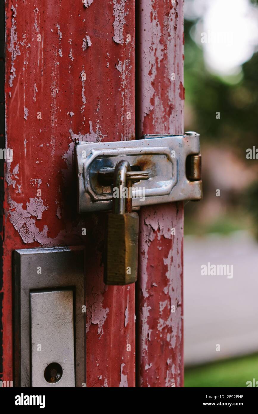 The old rusty padlock on the red door Stock Photo