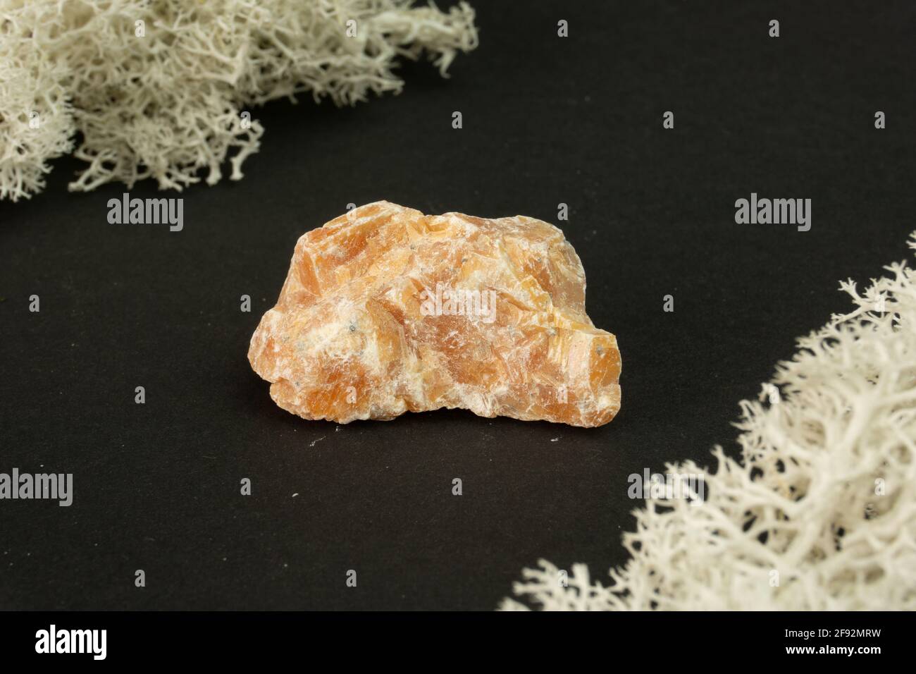 Orange Calcite from Brazil. Natural mineral stone on black background. Mineralogy, geology, magic of stones, semi-precious stones and samples of miner Stock Photo
