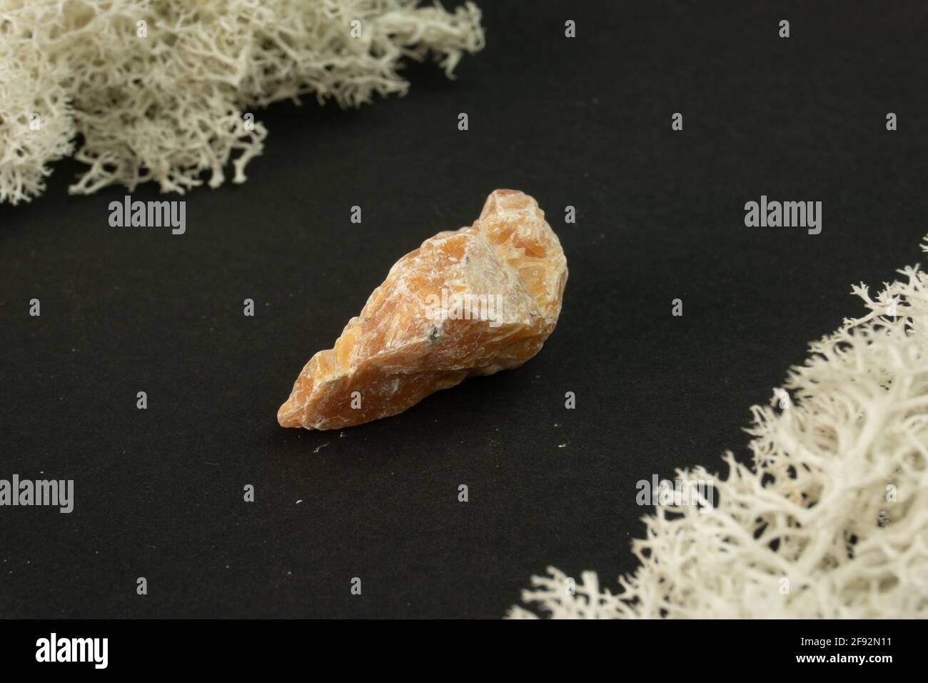 Orange Calcite from Brazil. Natural mineral stone on black background. Mineralogy, geology, magic of stones, semi-precious stones and samples of miner Stock Photo