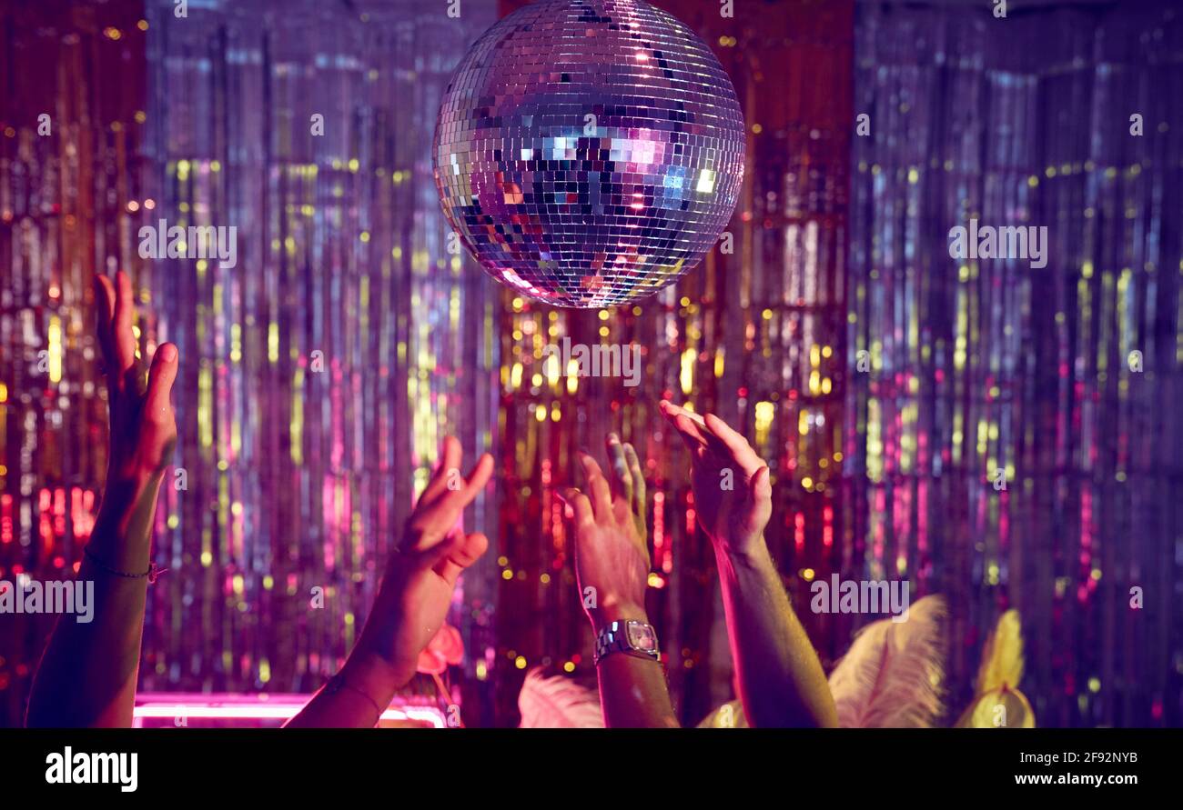 People dancing underneath a glitter ball with just the hands visible. Stock Photo