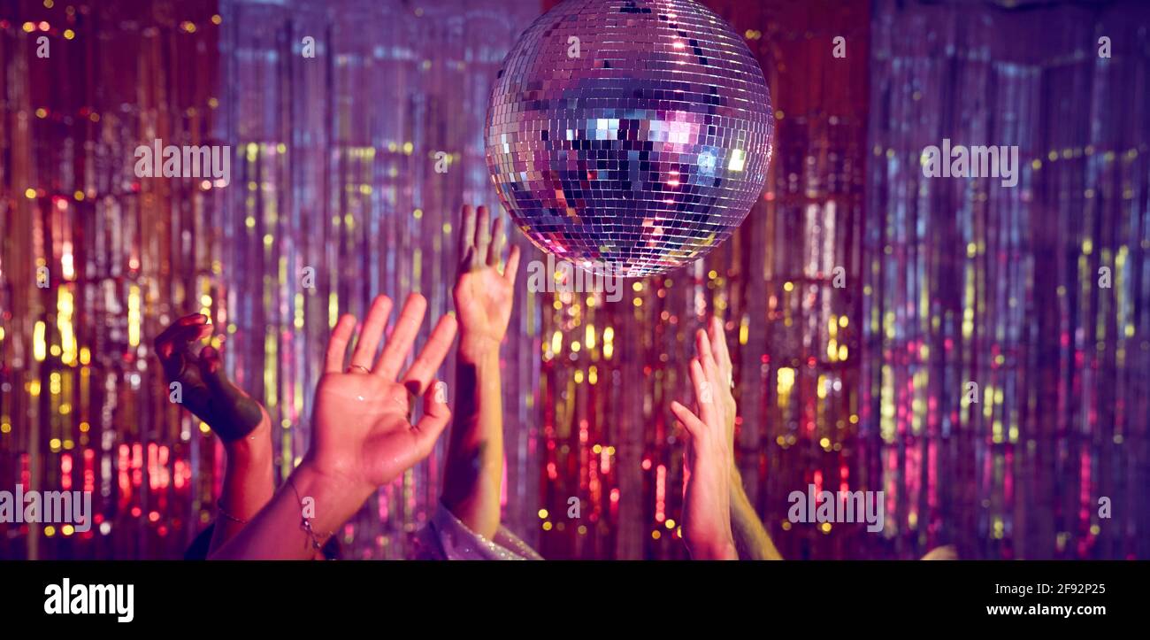 People dancing underneath a glitter ball with just the hands visible. Stock Photo