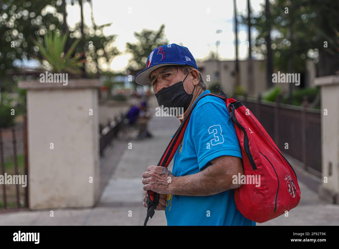 An older man wears a mask for Covid 19 and a blue cap from the defunct or  defunct Major League Baseball team, MLB, the Montreal Expos on April 15,  2021 in Hermosillo