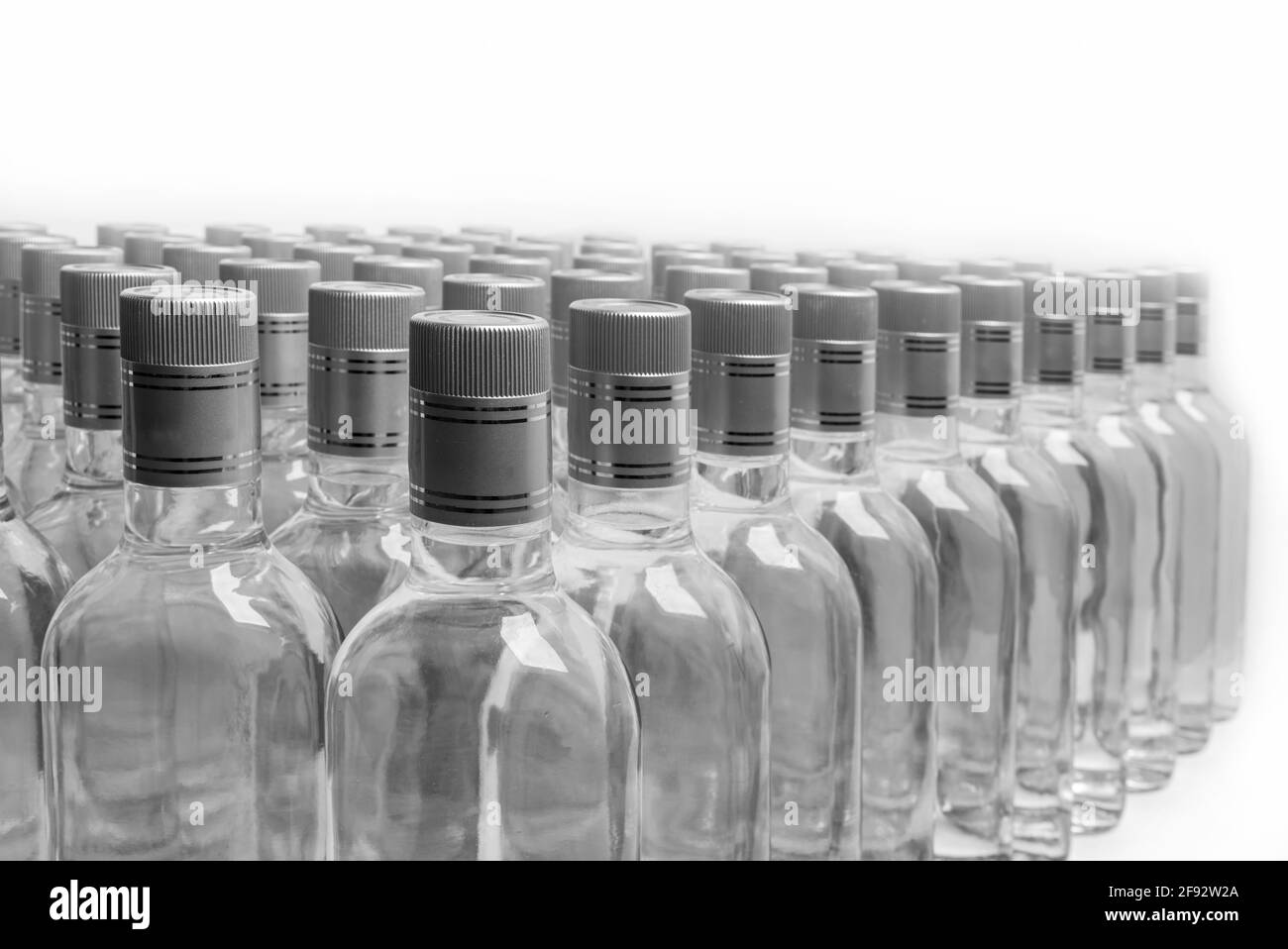 Bottles of pure alcohol not labeled. Multitude Bottles of Home Alcoholic Beverages Isolated On White. Small liquor production based on distillation. B Stock Photo