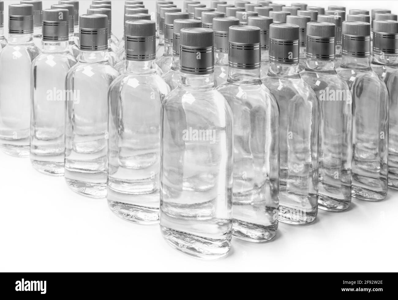Bottles of pure alcohol not labeled. Multitude Bottles of Home Alcoholic Beverages Isolated On White. Small liquor production based on distillation. B Stock Photo