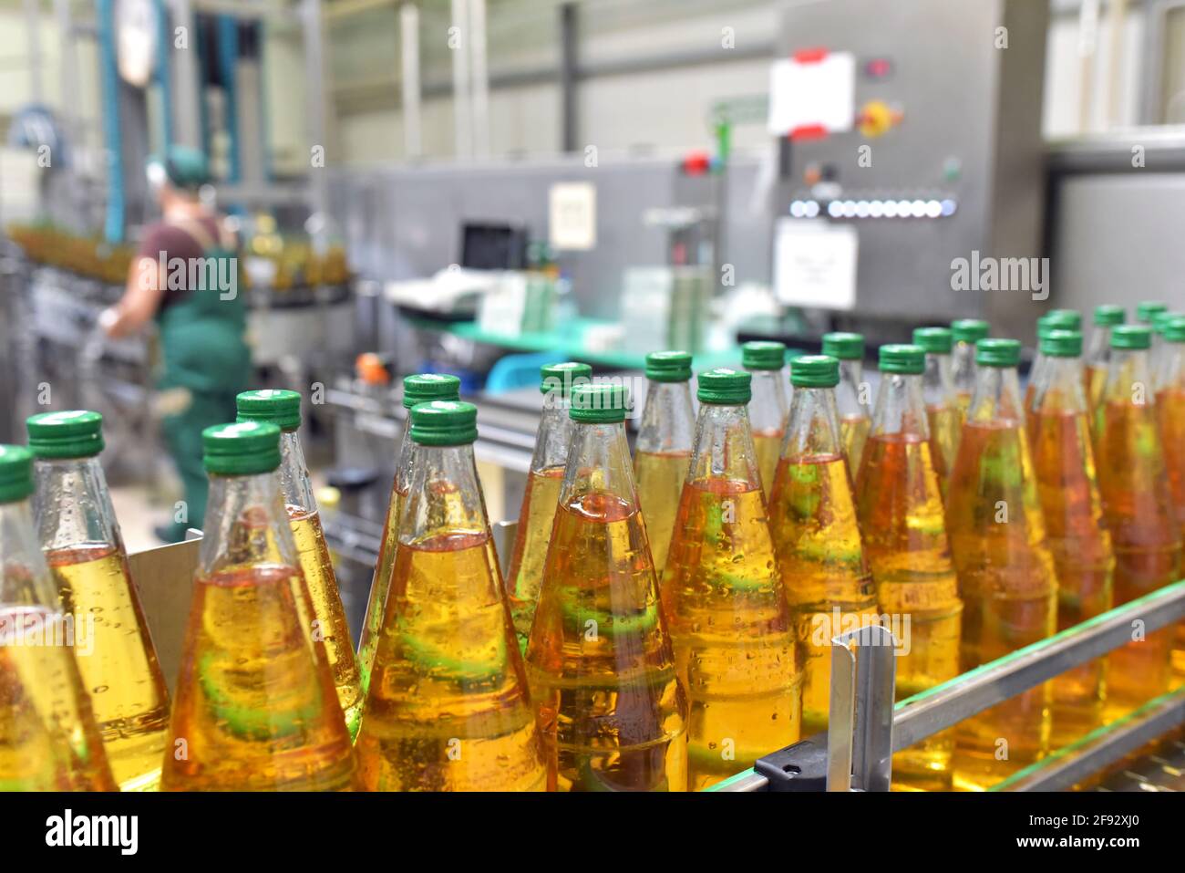 apple juice in glass bottles in a factory for the food industry - bottling and transport Stock Photo