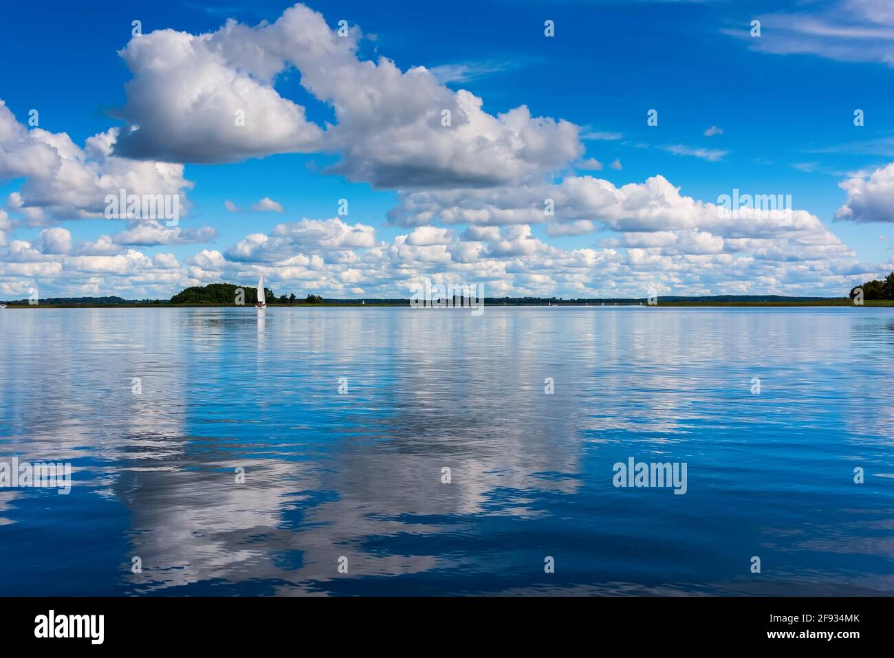beautiful reflections of a white clouds and blue sky on lake water ...
