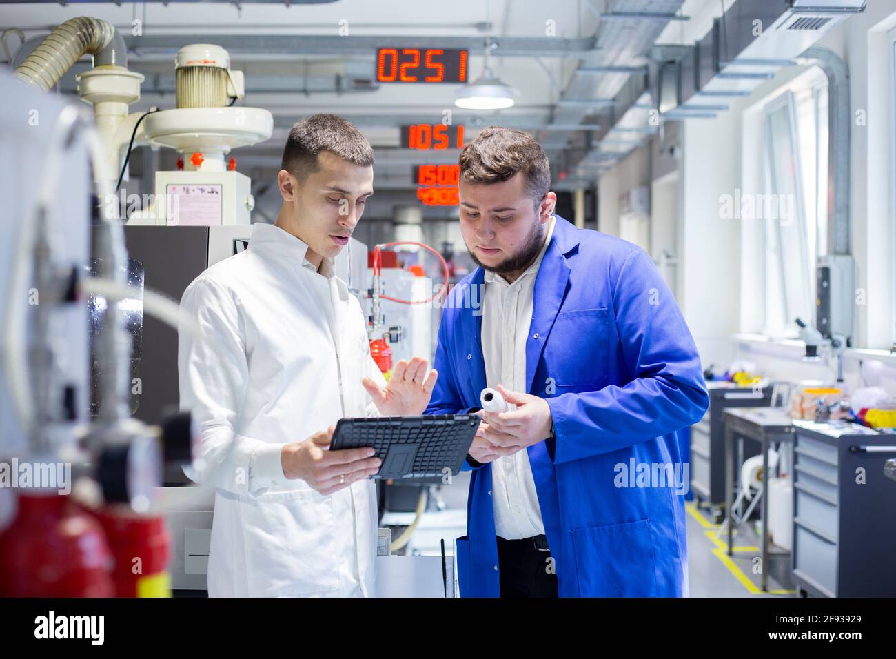 Engineer and technician discussing production process at factory Stock