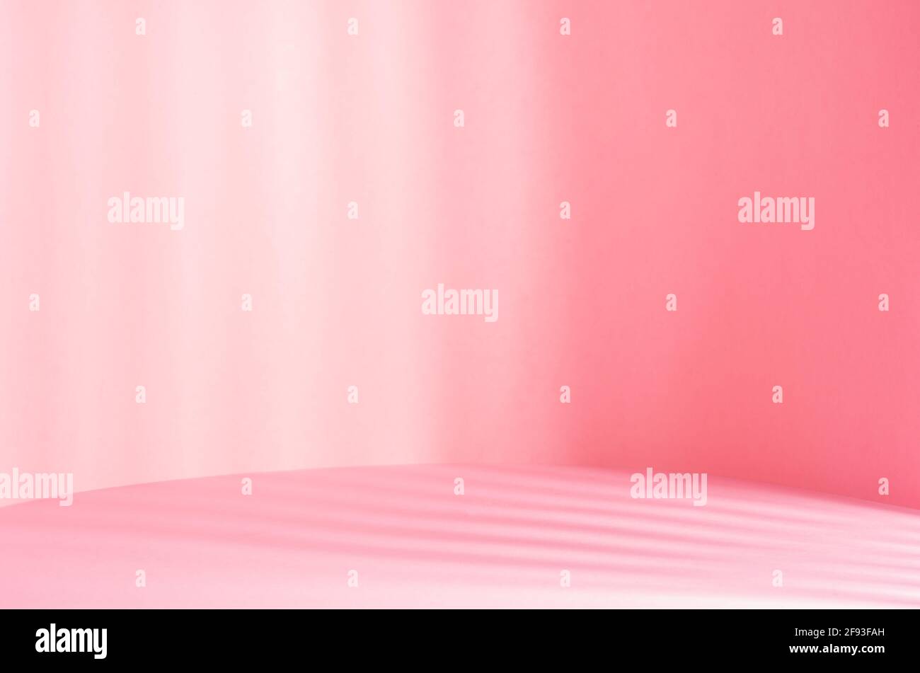 Bright pastel pink scene for display and presentation in sunny day with sun beams and striped shadows, spring delicate background. Stock Photo