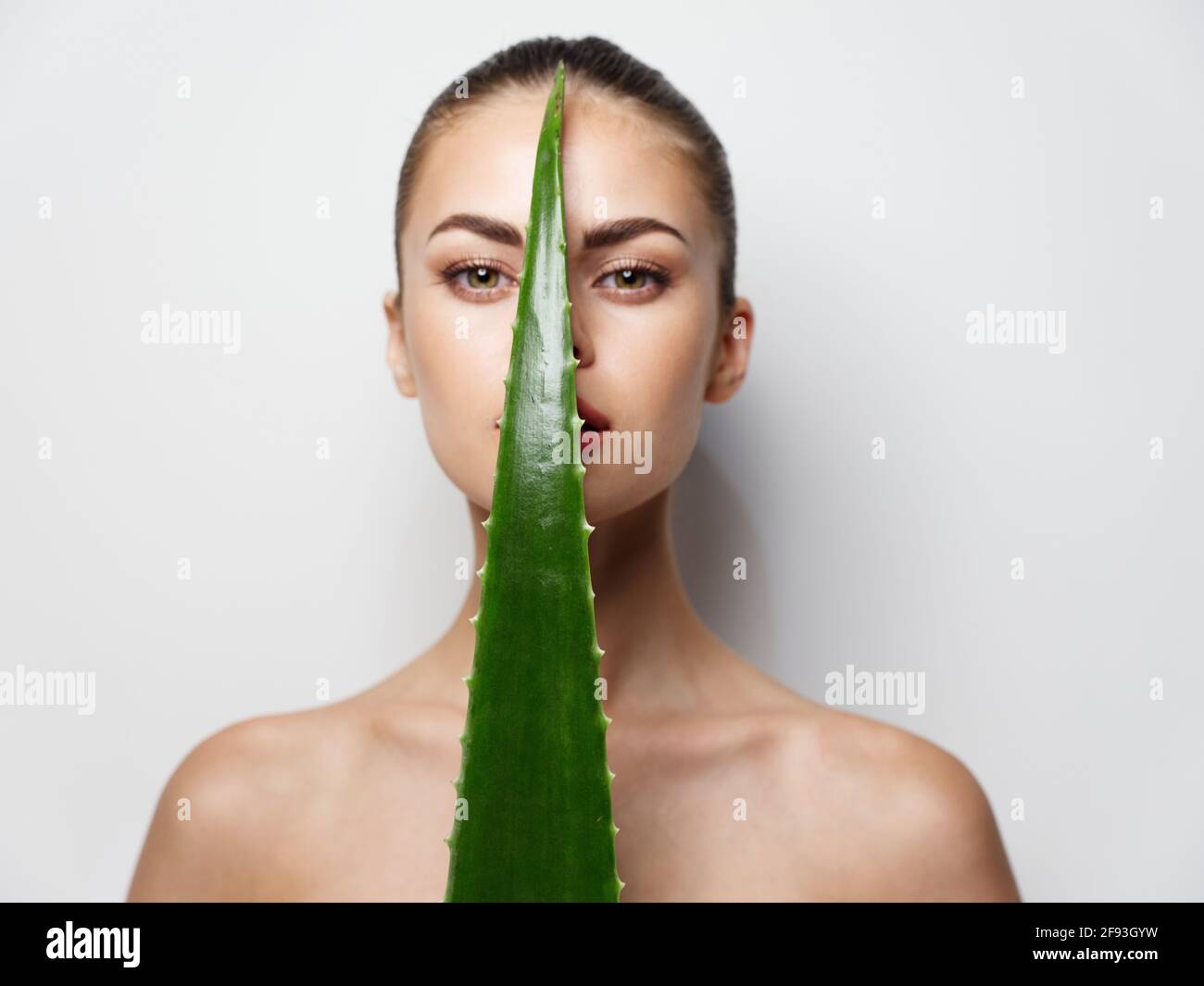 young woman with green aloe leaf in front of face Stock Photo Alamy