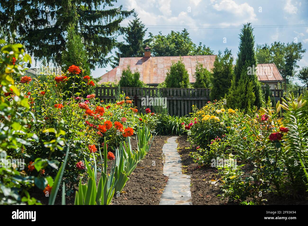 Flower garden houseHouse of a flower garden. Bushes of roses, lilies. Stock Photo