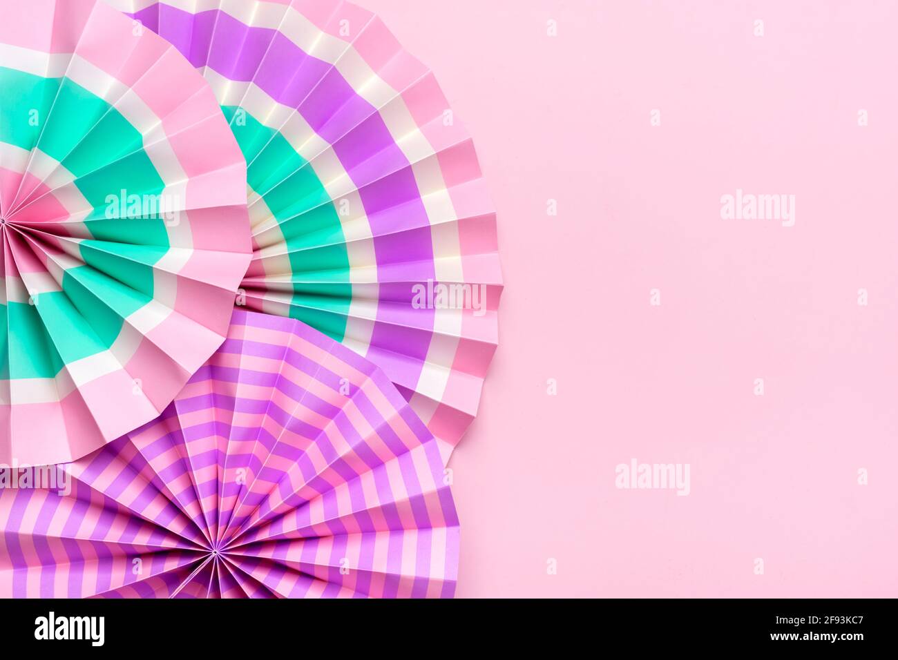 Traditional Japaneses festival paper fan with pink, turquoise, white stripes Birthday party, celebration holidays concept Abstract background Wall Stock Photo
