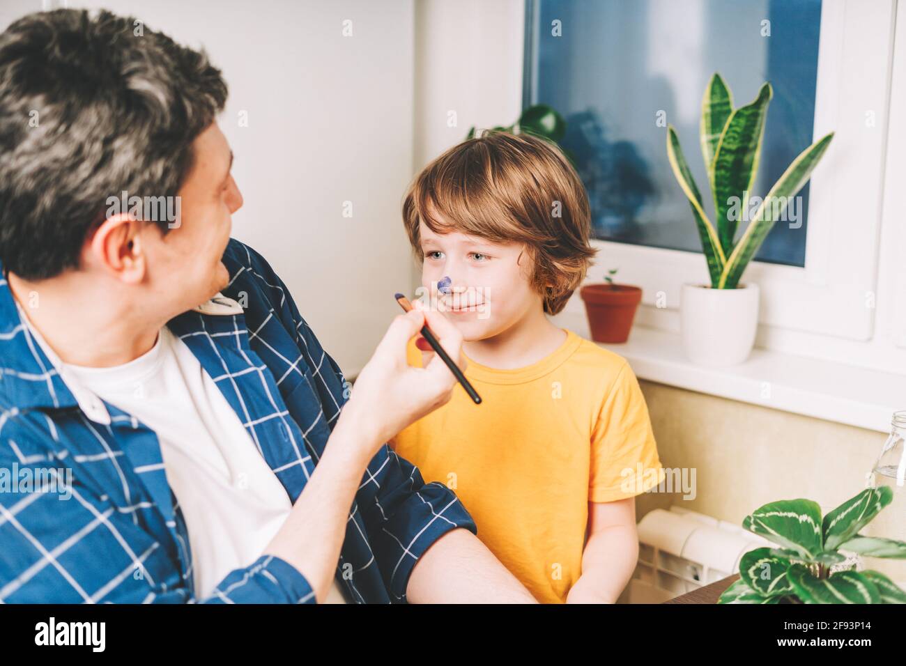 Father painted on the nose of child kid boy Stock Photo