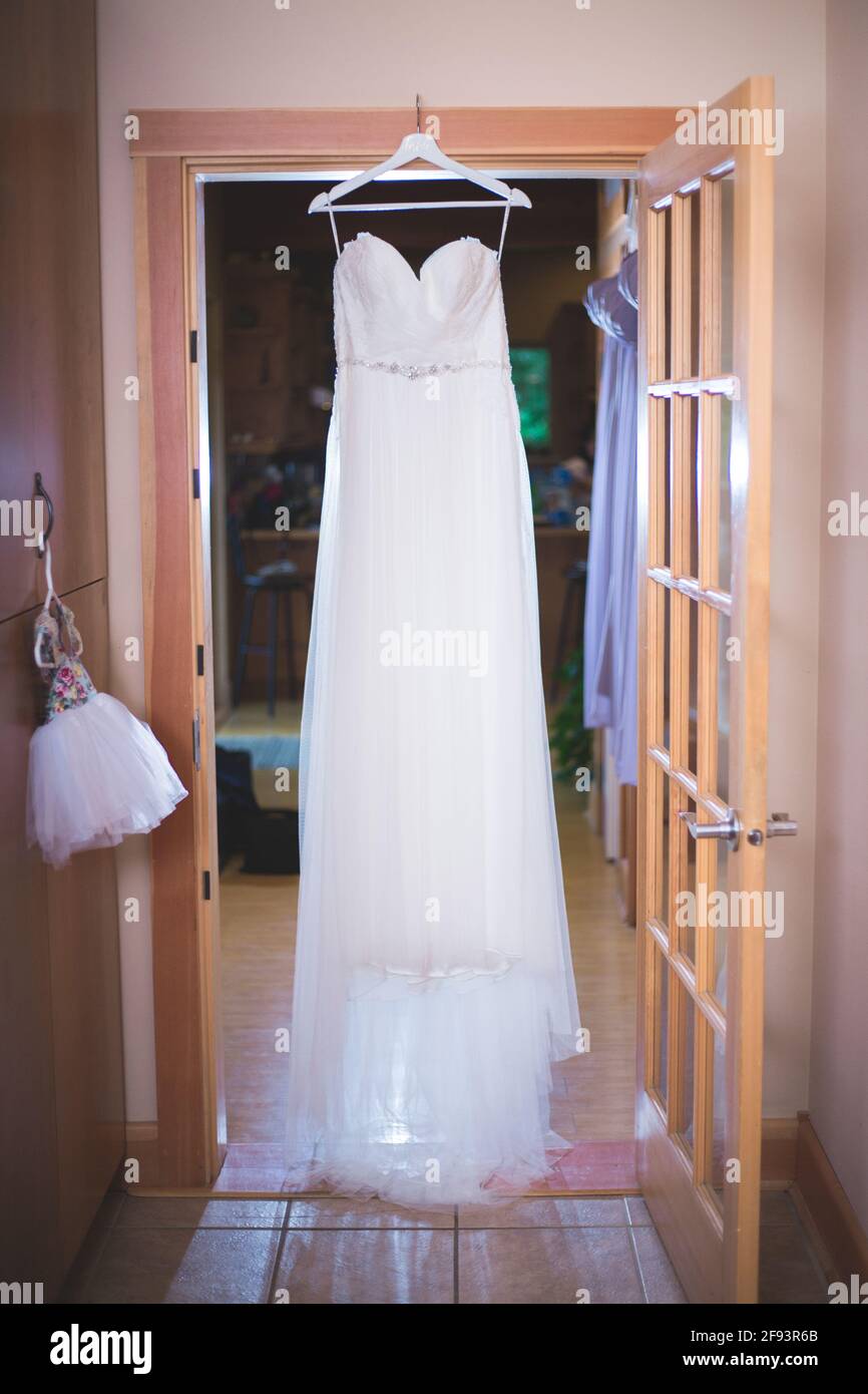 Bride's wedding dress hung up Stock Photo