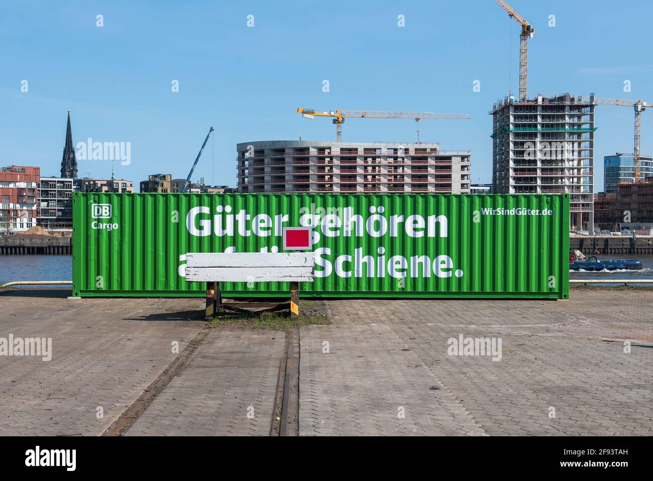 Hamburg, Germany. 16th Apr, 2021. A container with the inscription 'Güter gehören auf die Schiene' (Goods belong on the rails) stands on a track at a terminal at the port during a Deutsche Bahn press event. With this campaign, Deutsche Bahn wants to promote more climate-friendly freight transport. Credit: Daniel Bockwoldt/dpa/Daniel Bockwoldt/dpa/Alamy Live News Stock Photo