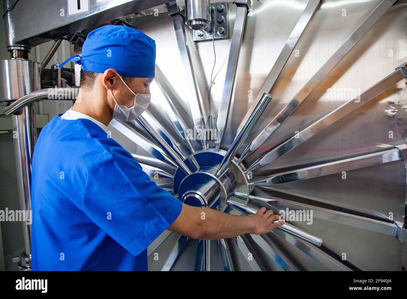 Atyrau, Kazakhstan. Medical syringe production plant.High-pressure sterilization autoclave. Man worker operator in face mask. Stock Photo