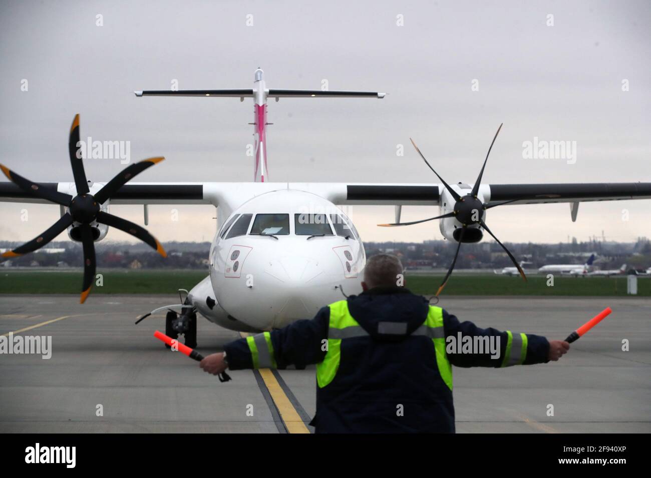 KYIV, UKRAINE - APRIL 16, 2021 - An aircraft marshaller signals an aeroplane that delivered the first batch of the Pfizer–BioNTech COVID-19 vaccine (Comirnaty) at Kyiv International Airport, Kyiv, capital of Ukraine. The first batch of the Pfizer–BioNTech vaccine that contains 117,000 doses is intended for the residents of care homes and the employees of the State Emergency Service and the State Border Guard Service. Credit: Ukrinform/Alamy Live News Stock Photo