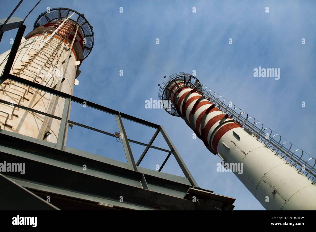 Modern gas power station. Smoke stacks on blue sky. Red and white stripes on tubes, wide-angle lens view. Uralsk city, Kazakhstan Stock Photo