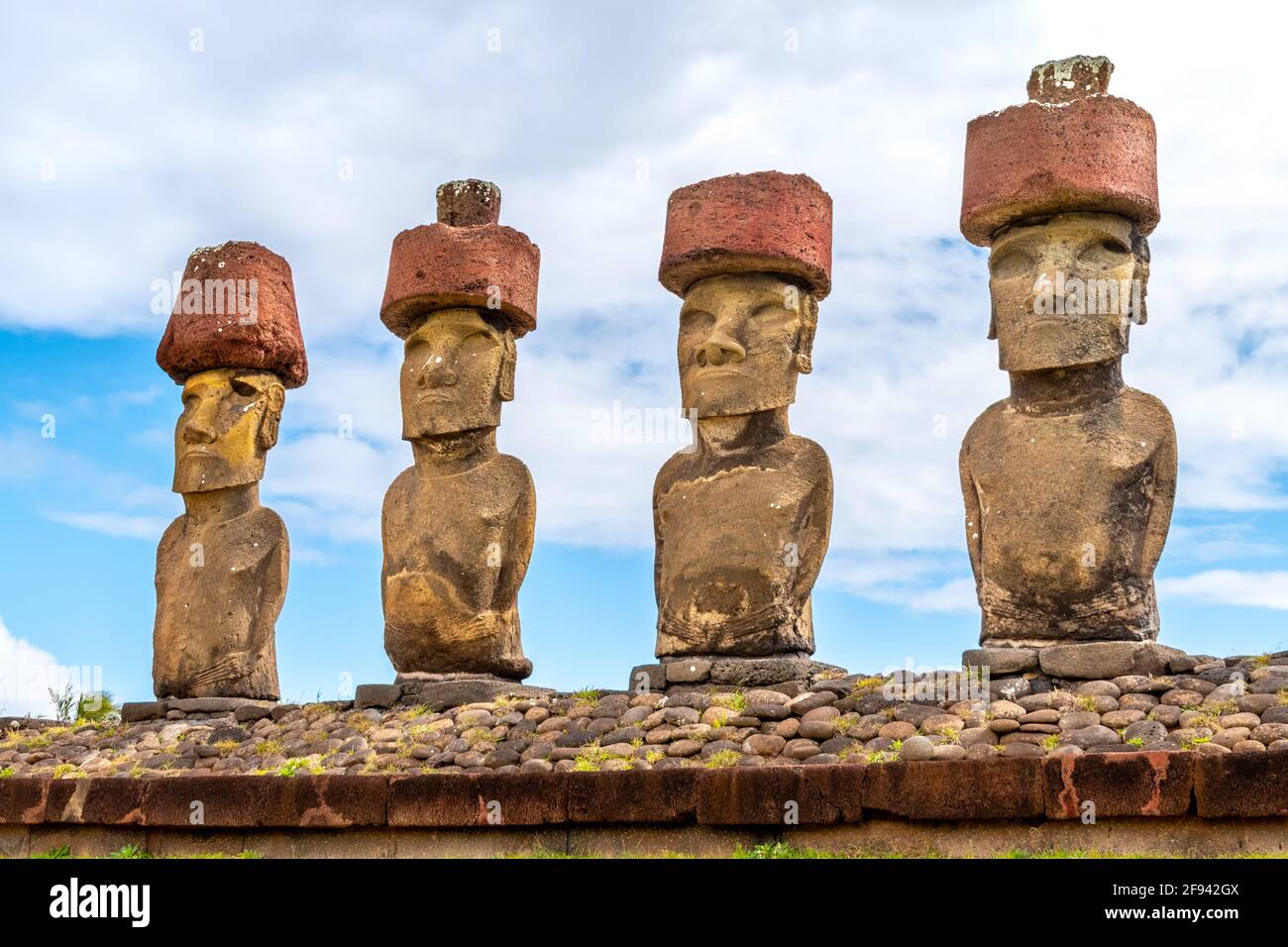 Moai with pukao against blu sky and clouds at Ahu Nau Nau on Anekena beach, Easter Island, Chile Stock Photo