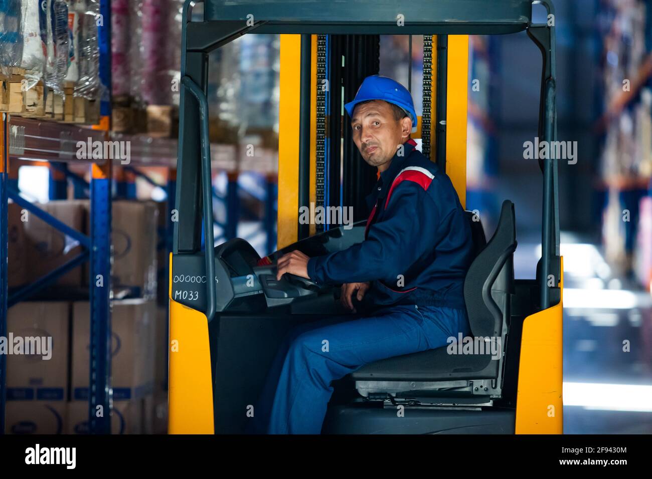 Portrait of hoist operator worker in cabin. Modern logistic centre and
