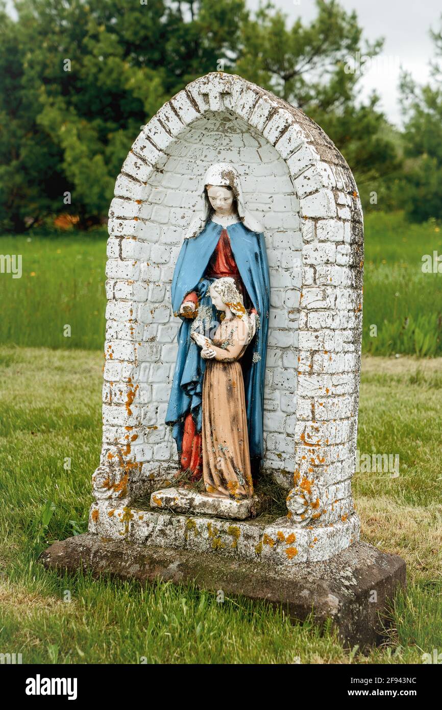 A madonna and child in a state of disrepair in an old abandoned churchyard. Stock Photo